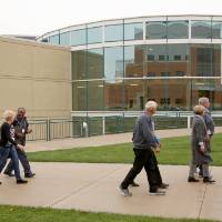 Class of '68 walks outside the Recreation Center on the campus tour.